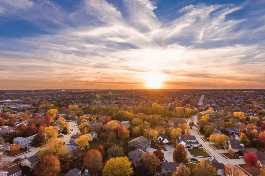 beautiful orange sunset over a quiet neighborhood in the fall with trees turning colors